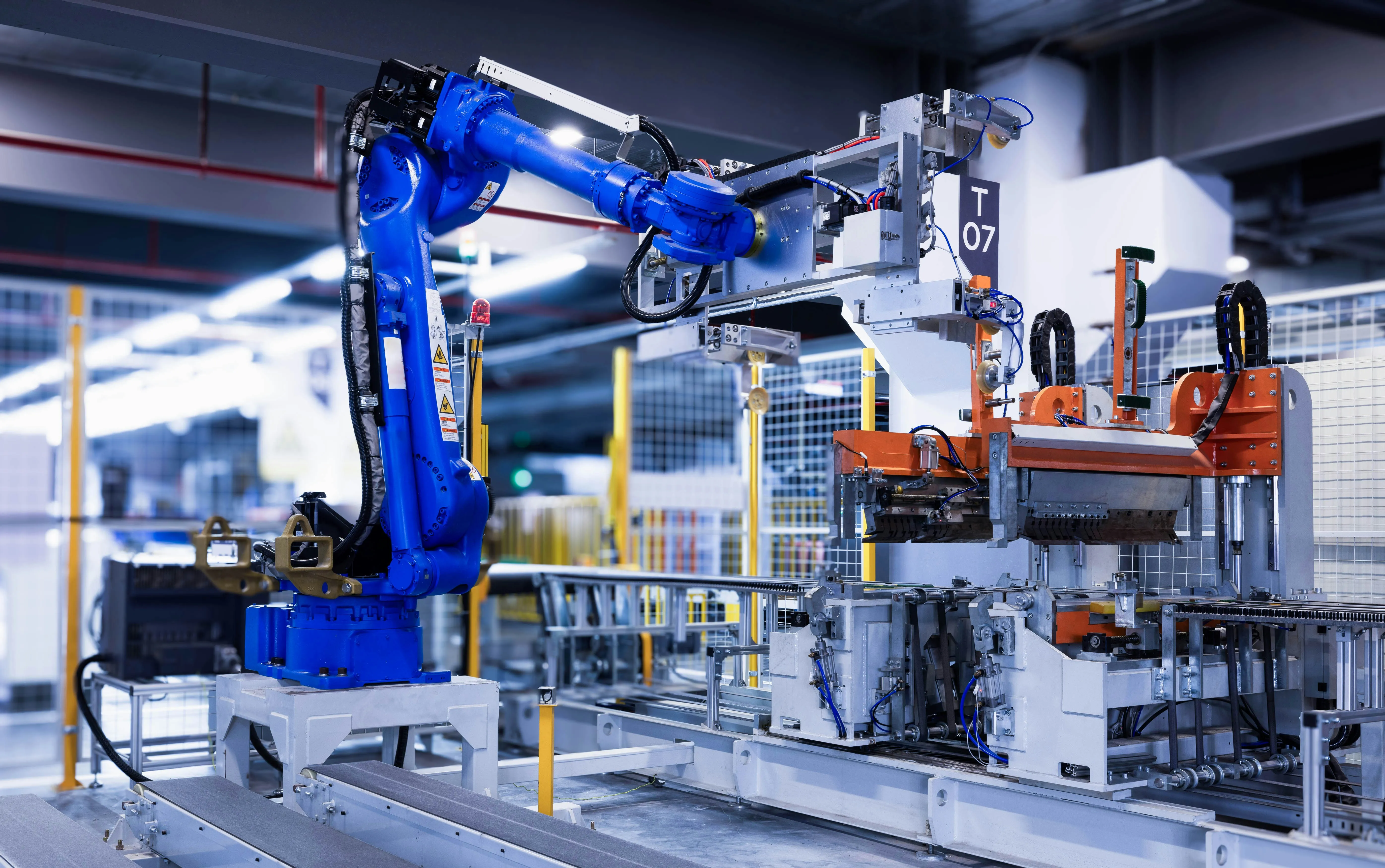 Close-up of the blue robot arm transporting a molded refrigeratorexterior laminate